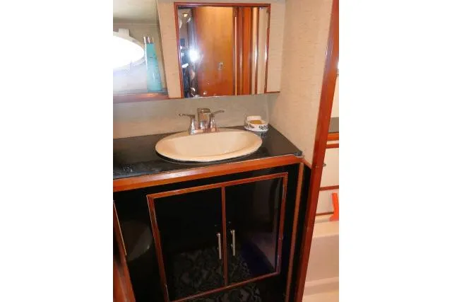Slide: The Image of Bathroom vanity in 1986 Ocean Alexander 39 Sedan yacht, featuring a sink and mirror. - 28