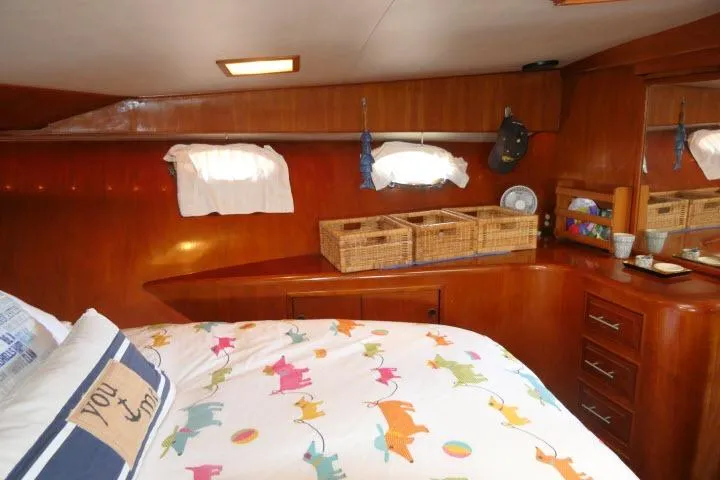 Slide: The Image of 1986 Ocean Alexander 39 Sedan cabin with colorful bedding and wooden storage. - 36