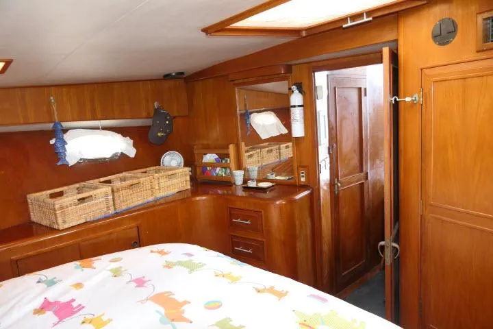 Slide: The Image of 1986 Ocean Alexander 39 Sedan interior with wooden cabinetry and colorful bedding. - 38