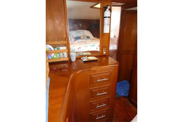 Slide: The Image of 1986 Ocean Alexander 39 Sedan interior with wooden cabinetry and cozy bedroom. - 39