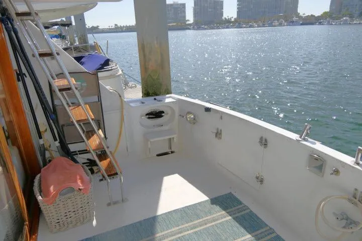 Slide: The Image of 1986 Ocean Alexander 39 Sedan yacht deck with waterfront view, featuring ladder and seating area. - 43