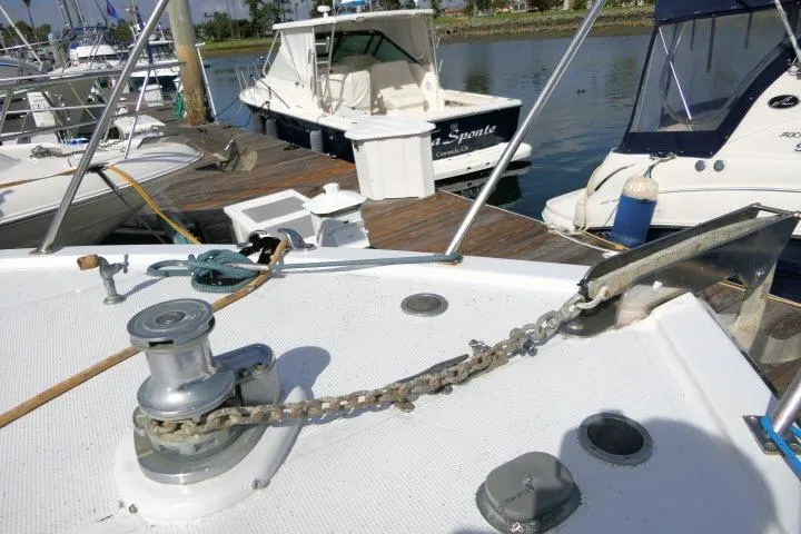 Slide: The Image of 1986 Ocean Alexander 39 Sedan yacht docked, showcasing anchor chain and winch on deck. - 58