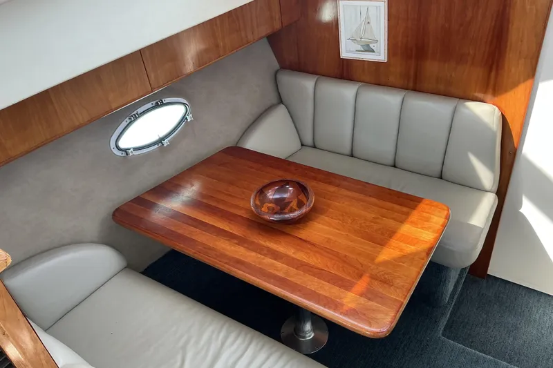 Slide: The Image of 1999 Silverton 422 Motor Yacht interior with wooden table and cushioned seating. - 14