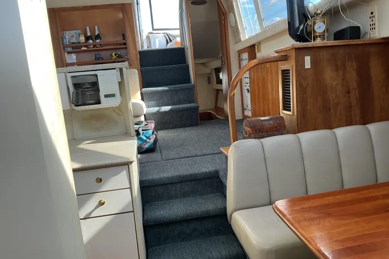 Slide: The Image of Interior of 1999 Silverton 422 Motor Yacht with cozy seating and kitchenette. - 18