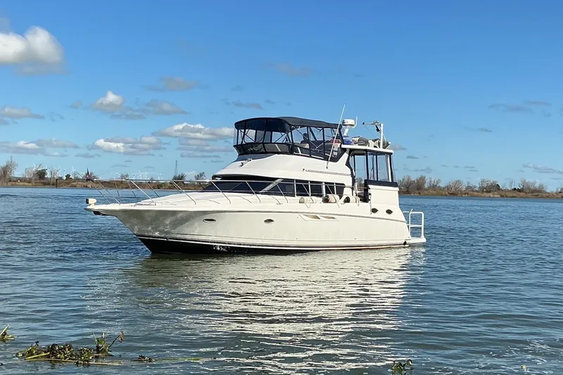 Slide: The Image of 1999 Silverton 422 Motor Yacht on calm water under clear blue sky. - 3