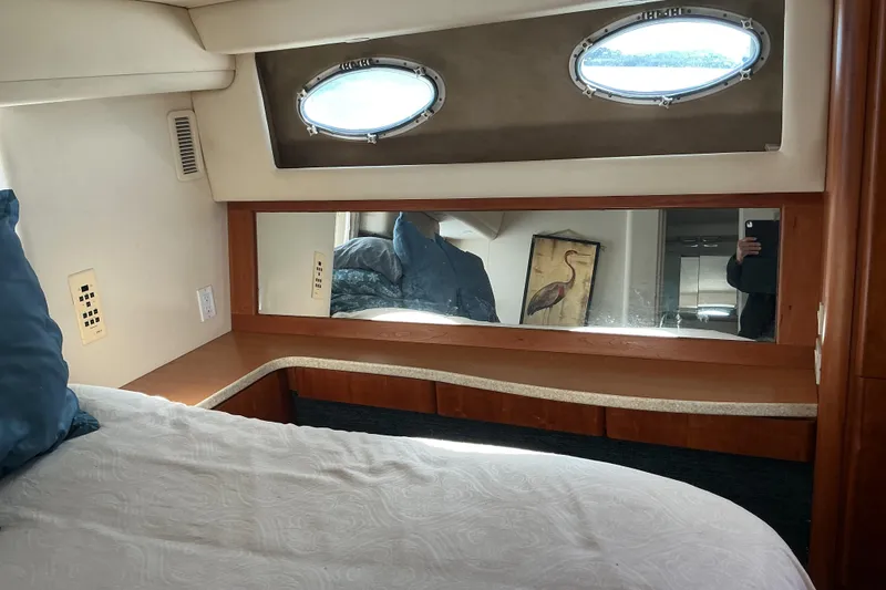 Slide: The Image of Interior of 1999 Silverton 422 Motor Yacht with bed, mirror, and porthole window. - 7