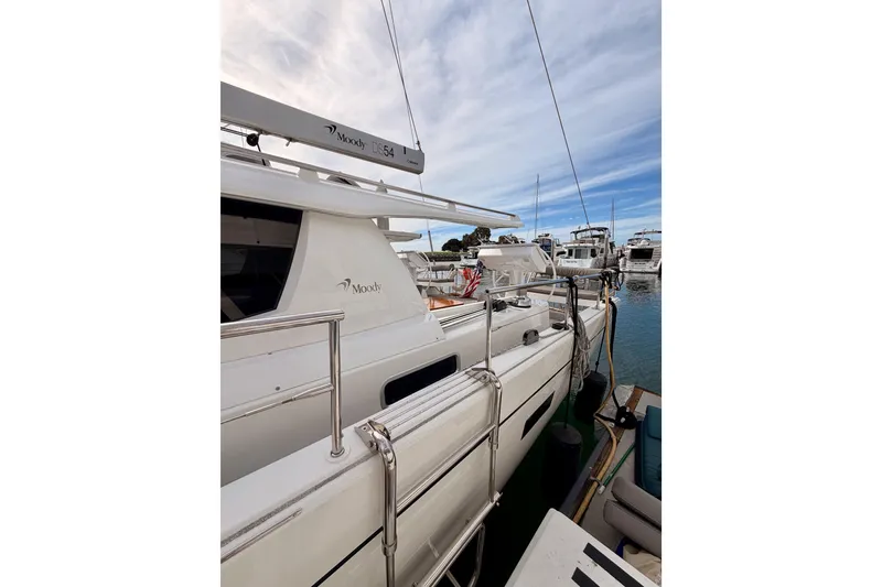 Slide: The Image of 2016 Moody Decksaloon 54 yacht docked at marina under blue sky. - 11