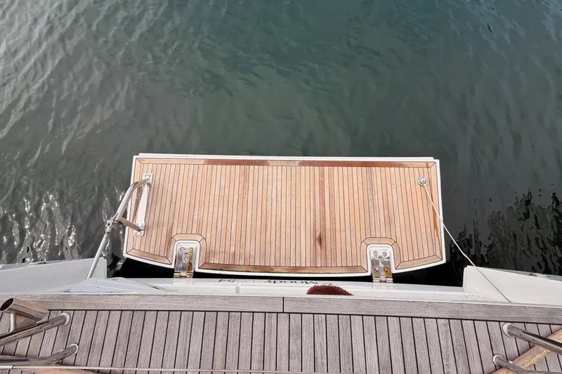 Slide: The Image of Teak swim platform on 2016 Moody Decksaloon 54 yacht, docked on calm water. - 128