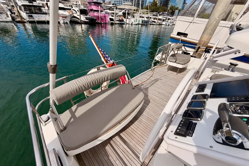 Slide: The Image of Luxurious 2016 Moody Decksaloon 54 yacht docked in a marina, featuring elegant deck seating. - 35