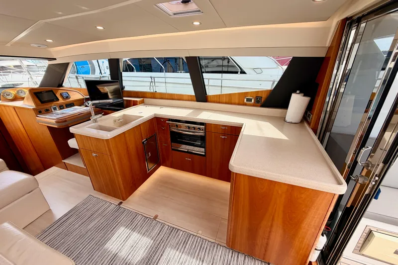 Slide: The Image of Luxurious 2016 Moody Decksaloon 54 yacht interior with modern kitchen and wooden cabinetry. - 54
