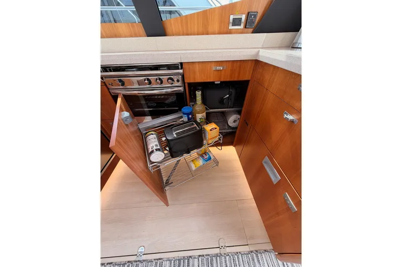 Slide: The Image of Modern kitchen interior of 2016 Moody Decksaloon 54 yacht with open storage cabinet. - 60