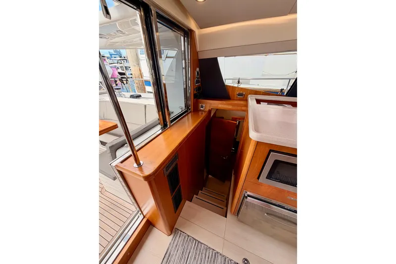 Slide: The Image of Interior view of 2016 Moody Decksaloon 54 yacht, featuring wooden cabinetry and modern appliances. - 64