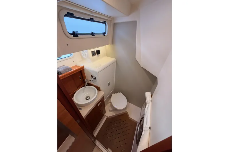 Slide: The Image of 2016 Moody Decksaloon 54 yacht bathroom with sink, toilet, and window. - 66