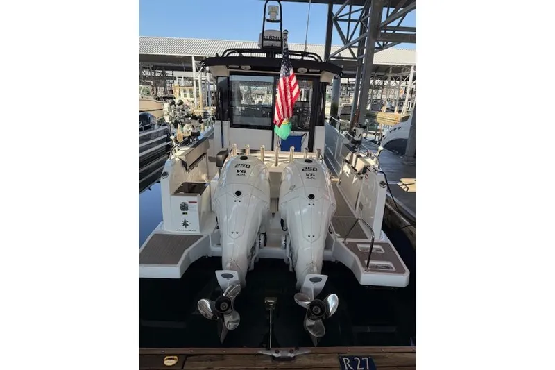 The Image of 2024 Jeanneau NC 895 Sport boat docked in a marina, surrounded by other vessels. - 0