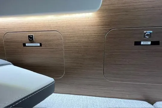 Slide: The Image of 2024 Jeanneau NC 895 Sport cabin interior with modern wood finish and cozy bedding. - 12