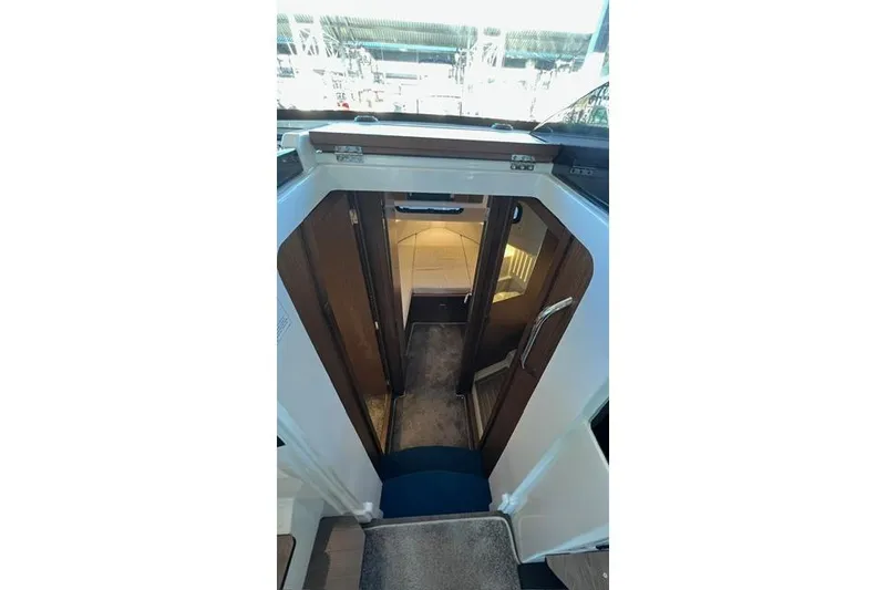 Slide: The Image of Interior storage compartments of 2024 Jeanneau NC 895 Sport boat, featuring sleek wood finish. - 13