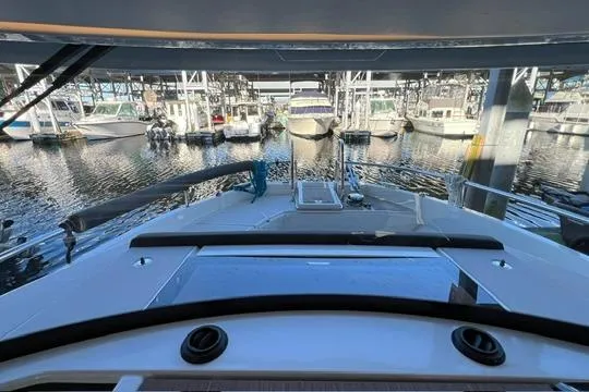 Slide: The Image of 2024 Jeanneau NC 895 Sport interior with modern dashboard and marina view. - 9