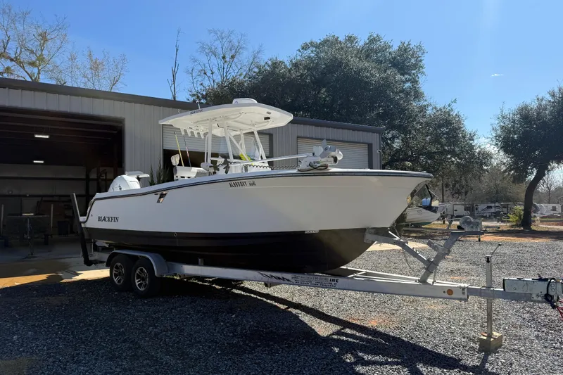 The Image of 2019 Blackfin 242 CC boat on trailer outside a garage, sunny day. - 34