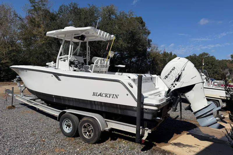 Slide: The Image of 2019 Blackfin 242 CC boat on trailer with powerful outboard motor, parked outdoors. - 36