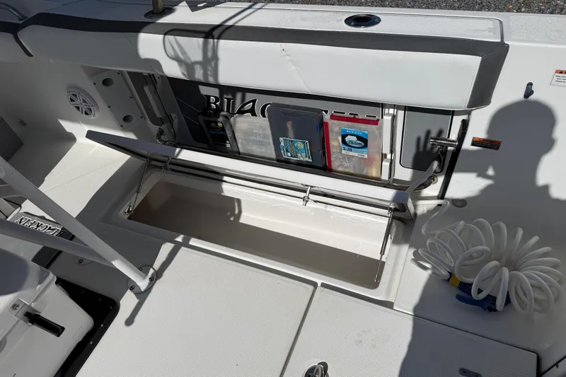 Slide: The Image of 2019 Blackfin 242 CC boat interior with storage compartment and coiled rope. - 40
