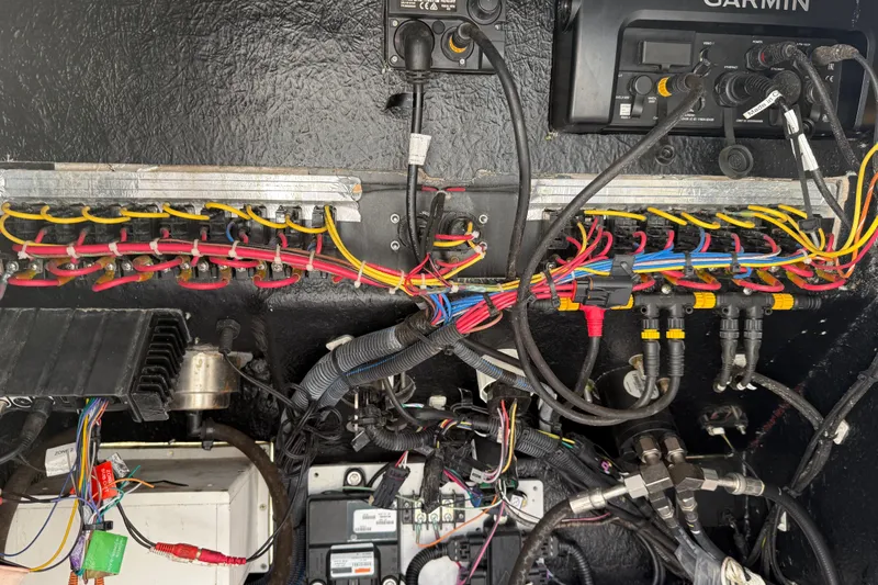 Slide: The Image of Electrical wiring and components inside a 2019 Blackfin 242 CC boat, featuring a Garmin device. - 54