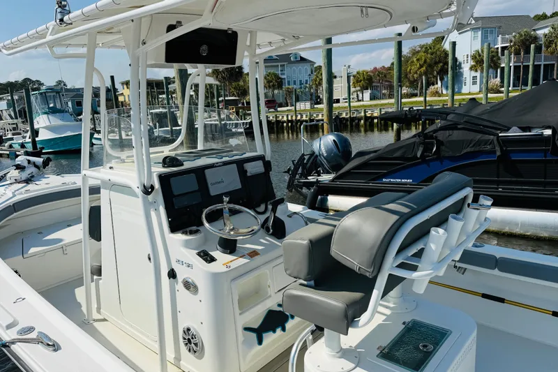 Slide: The Image of 2018 Parker 23SE Center Console boat docked at marina, featuring modern controls and seating. - 13