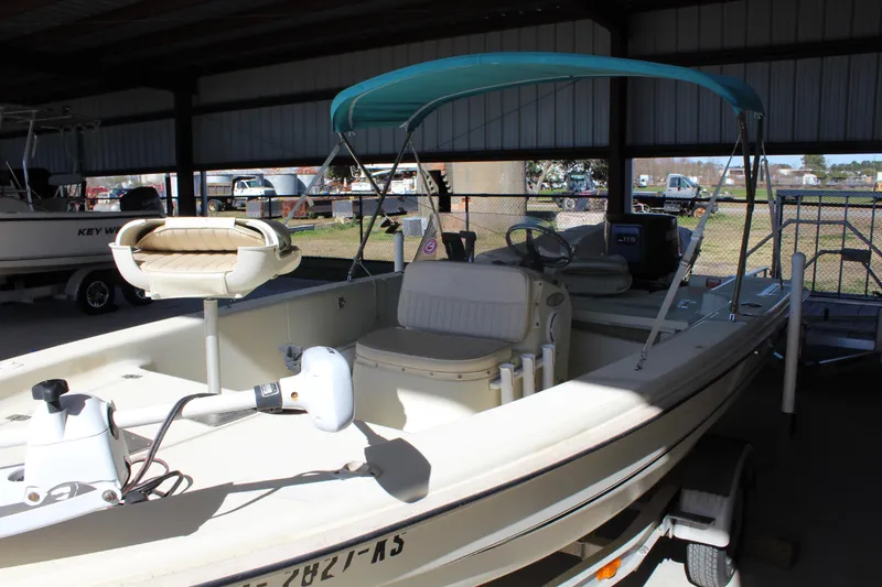 Slide: The Image of 1999 Scout 177 Sportfish boat with canopy, parked in a covered area. - 7
