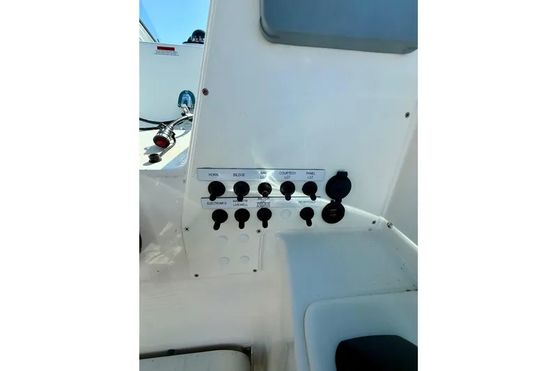 Slide: The Image of Control panel of a 2019 Aquasport 215 Explorer boat, featuring various switches and outlets. - 9