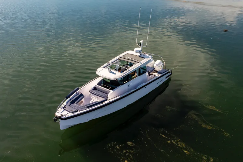 Slide: The Image of 2024 Axopar 29 XC Cross Cabin boat on calm water, aerial view. - 11
