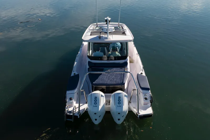 Slide: The Image of 2024 Axopar 29 XC Cross Cabin boat with dual engines on calm water. - 12