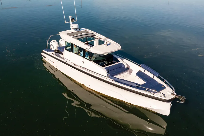 Slide: The Image of 2024 Axopar 29 XC Cross Cabin boat on calm water, featuring sleek design and modern amenities. - 13