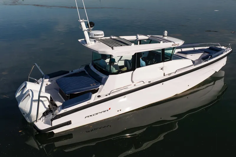Slide: The Image of 2024 Axopar 29 XC Cross Cabin boat on calm water, side view. - 14