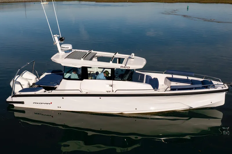 Slide: The Image of 2024 Axopar 29 XC Cross Cabin boat on calm water, showcasing sleek design and modern features. - 15