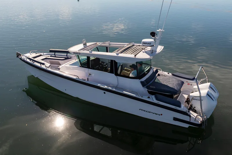 Slide: The Image of 2024 Axopar 29 XC Cross Cabin boat on calm water, featuring sleek design and modern amenities. - 16