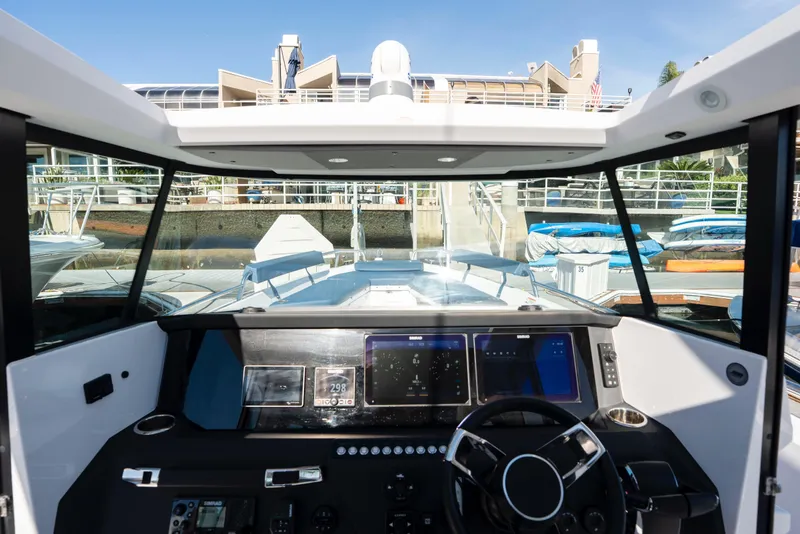 Slide: The Image of 2024 Axopar 29 XC Cross Cabin boat interior with modern dashboard and steering wheel. - 17
