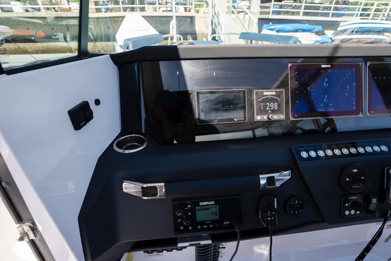 Slide: The Image of 2024 Axopar 29 XC Cross Cabin dashboard with Simrad navigation displays and controls. - 20