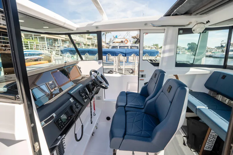 Slide: The Image of 2024 Axopar 29 XC Cross Cabin interior with modern dashboard and blue seating. - 26