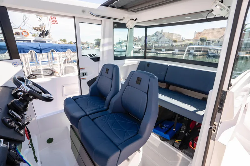 Slide: The Image of 2024 Axopar 29 XC Cross Cabin interior with blue seating and modern design. - 27