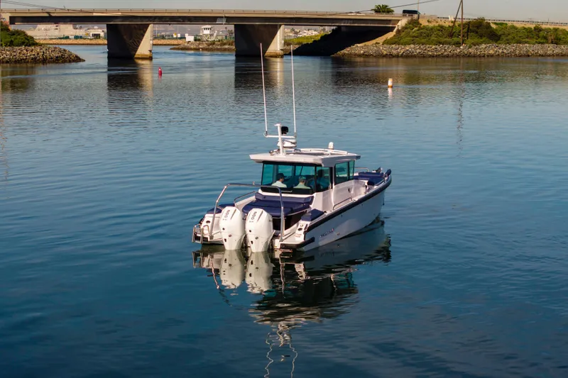 Slide: The Image of 2024 Axopar 29 XC Cross Cabin boat on calm water near a bridge. - 3
