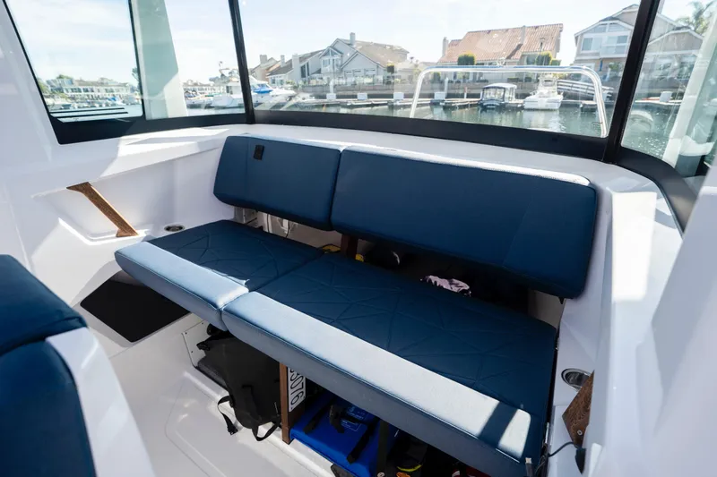 Slide: The Image of Interior of 2024 Axopar 29 XC Cross Cabin with blue seating and marina view. - 30
