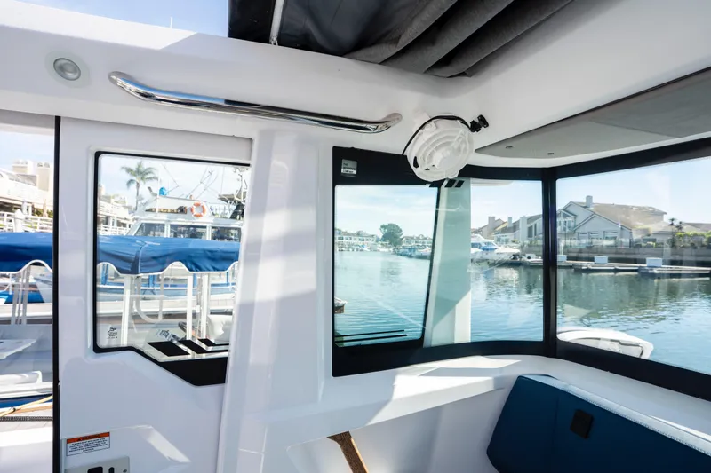 Slide: The Image of 2024 Axopar 29 XC Cross Cabin interior with waterfront view through large windows. - 33