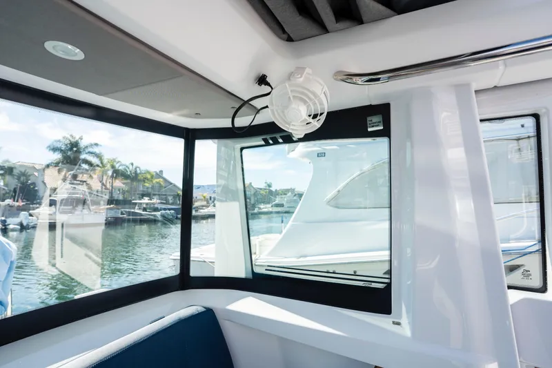 Slide: The Image of 2024 Axopar 29 XC Cross Cabin interior with marina view through large windows. - 34
