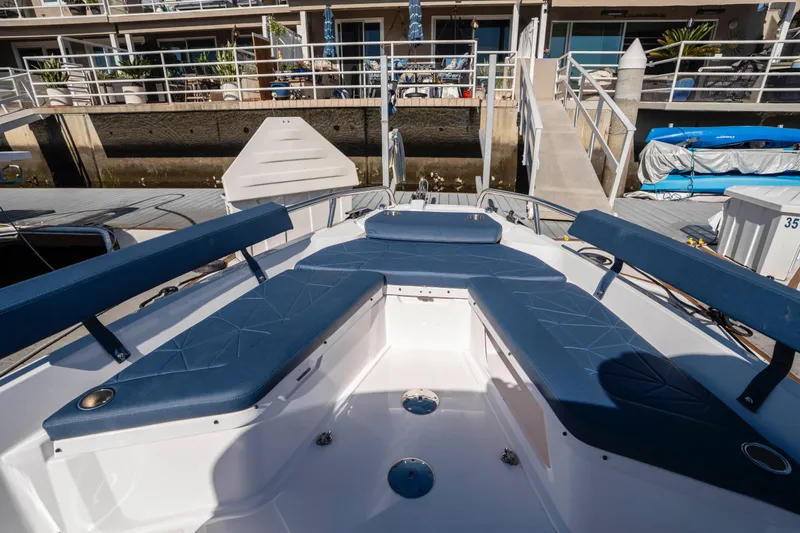 Slide: The Image of 2024 Axopar 29 XC Cross Cabin boat with blue seating at a marina dock. - 36