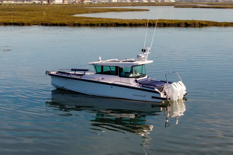 Slide: The Image of 2024 Axopar 29 XC Cross Cabin boat on calm water, showcasing sleek design. - 4