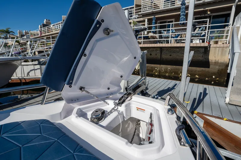 Slide: The Image of 2024 Axopar 29 XC Cross Cabin anchor compartment with open hatch at marina. - 41