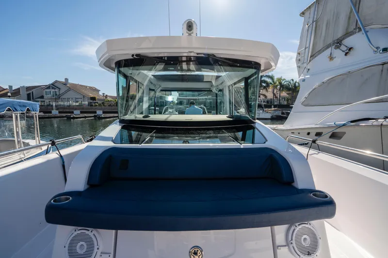 Slide: The Image of 2024 Axopar 29 XC Cross Cabin boat docked in a marina under clear skies. - 44