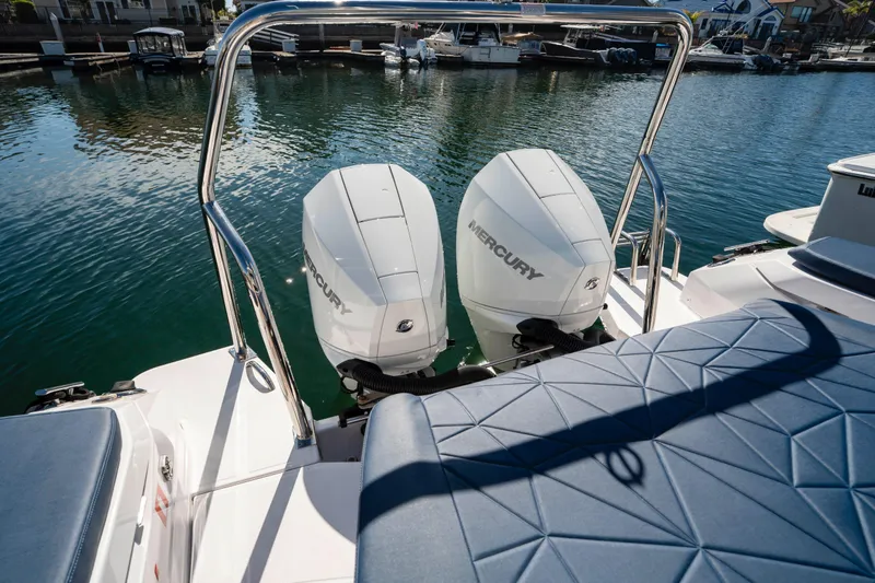 Slide: The Image of 2024 Axopar 29 XC Cross Cabin with dual Mercury outboard engines on a calm marina. - 54