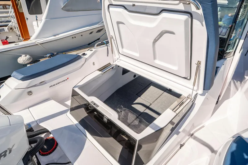 Slide: The Image of 2024 Axopar 29 XC Cross Cabin boat with open storage compartment at dock. - 56