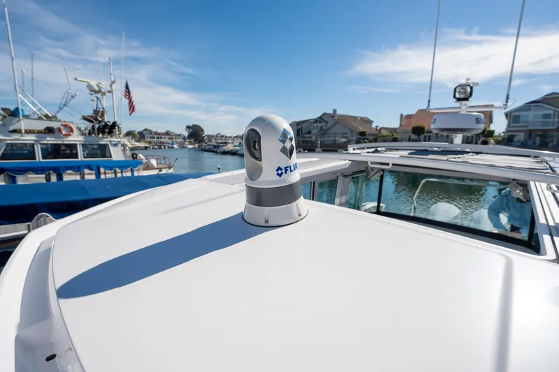 Slide: The Image of 2024 Axopar 29 XC Cross Cabin with FLIR camera, docked in a marina. - 58