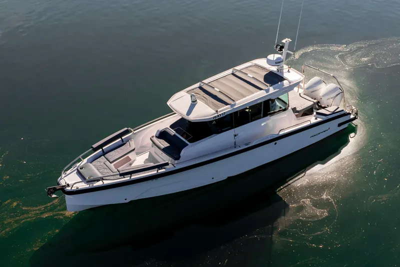 Slide: The Image of 2024 Axopar 29 XC Cross Cabin boat on calm water, aerial view. - 9